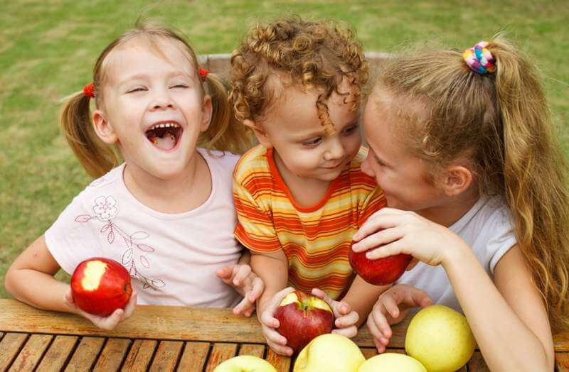 three-happy-children-sitting-at-the-table-and-eat