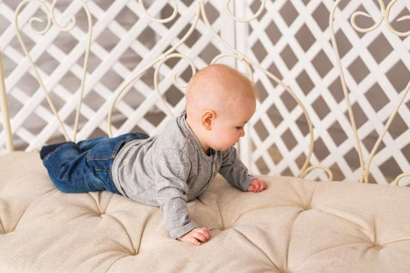 adorable-baby-boy-in-white-sunny-bedroom