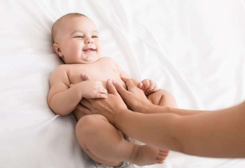 masseur-massaging-tummy-of-baby-during-colic