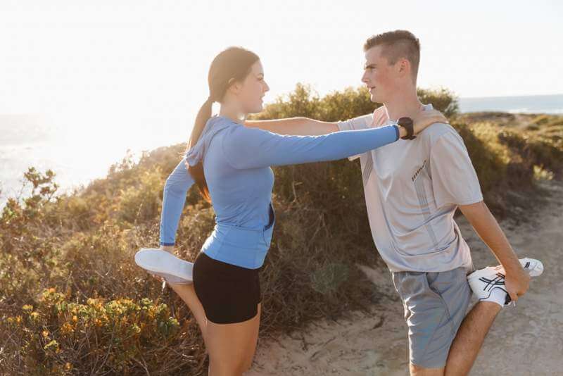 young-couple-on-beach-training-together