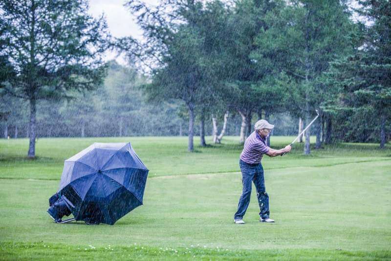 golfer-on-a-rainy-day-swigning-in-the-fairway