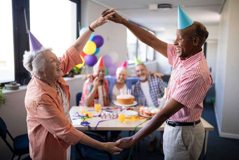 senior-couple-making-frame-against-friends