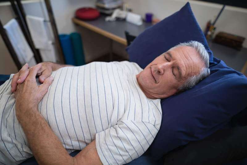 high-angle-view-of-senior-man-sleeping-on-bed