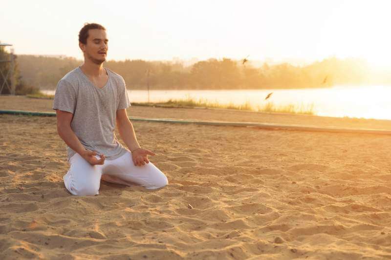 young-attractive-man-meditating-on-the-beach