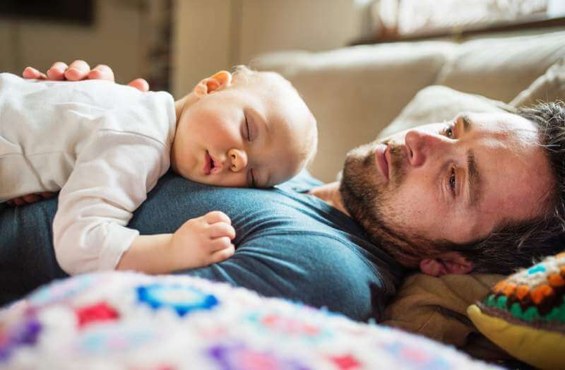 father-with-a-sleeping-baby-girl-at-home