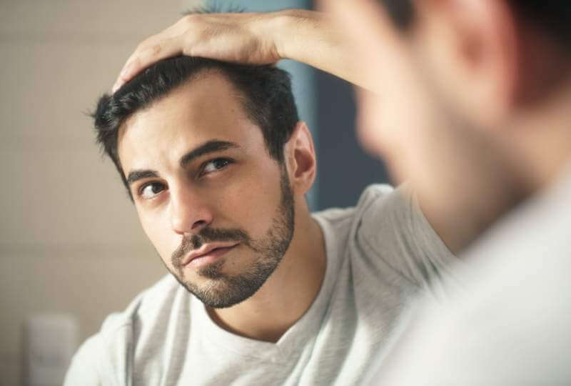 man-worried-for-alopecia-checking-hair-for-loss