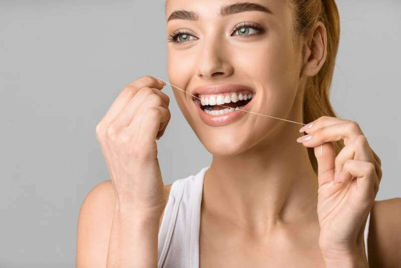 tooth-care-young-woman-using-dental-floss