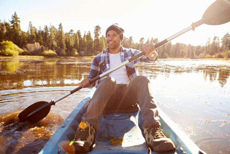 young-man-rowing-kayak-on-lake