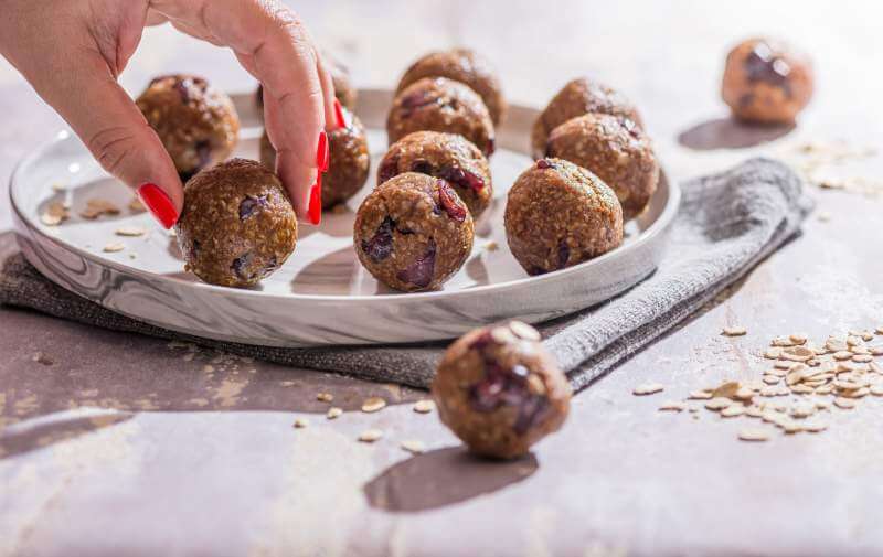 oatmeal-balls-oats-dates-and-cranberries-energy-balls-with-woman-hand-holding