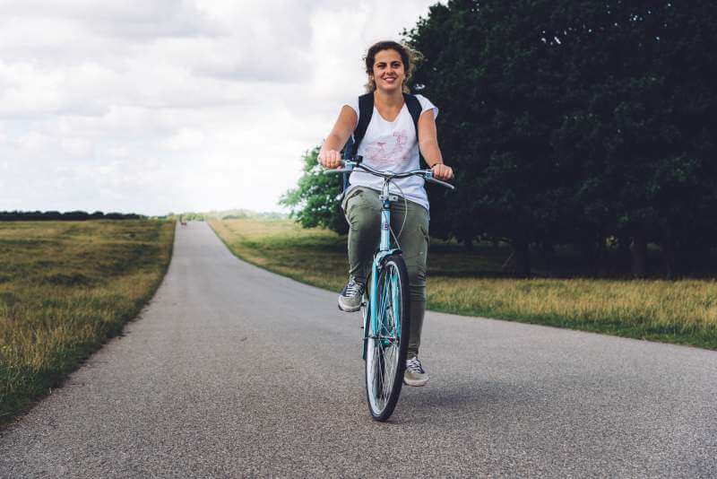 smiling-young-woman-riding-mountain-bike